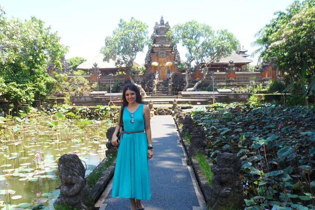 uma mulher de vestido azul em pé em frente a um lago