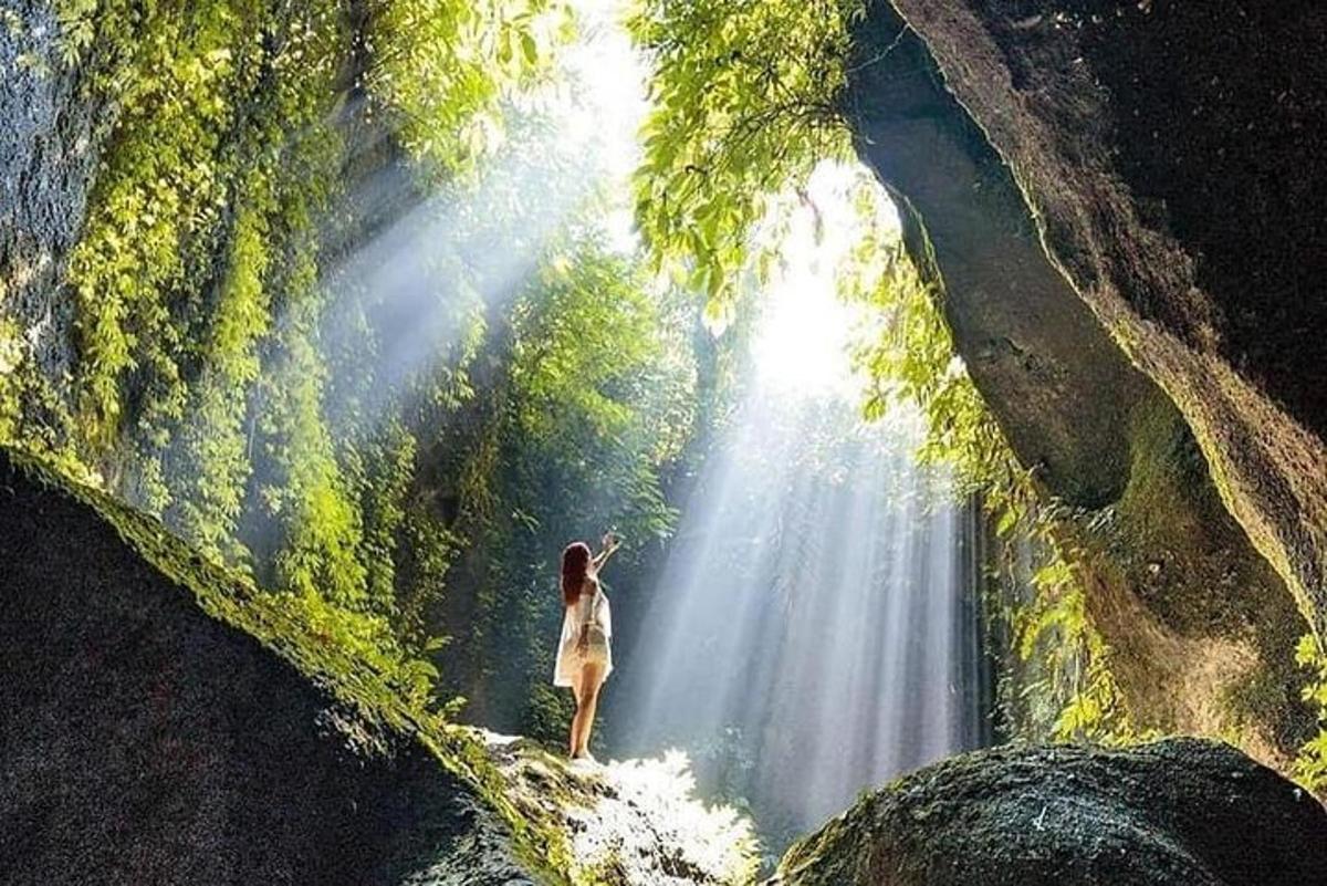 seorang wanita berdiri di depan air terjun