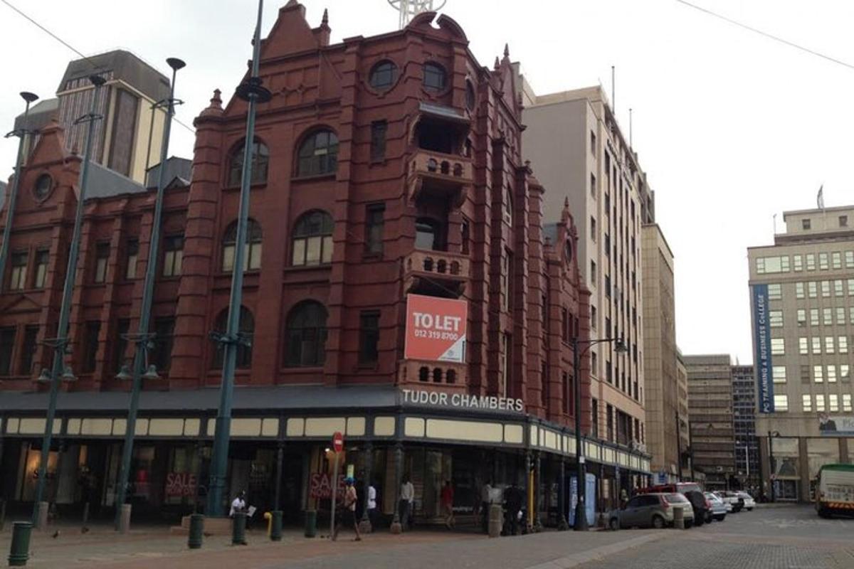 ein großes rotes Backsteingebäude an einer Stadtstraße