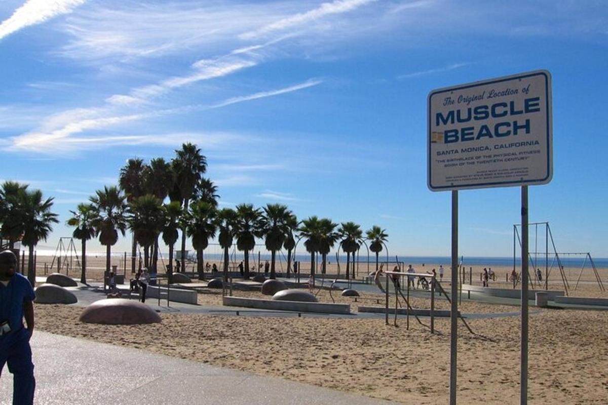 a sign in front of a beach with palm trees