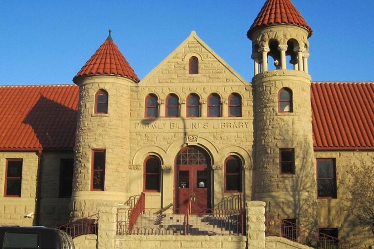 a large brick building with a tower with a red roof