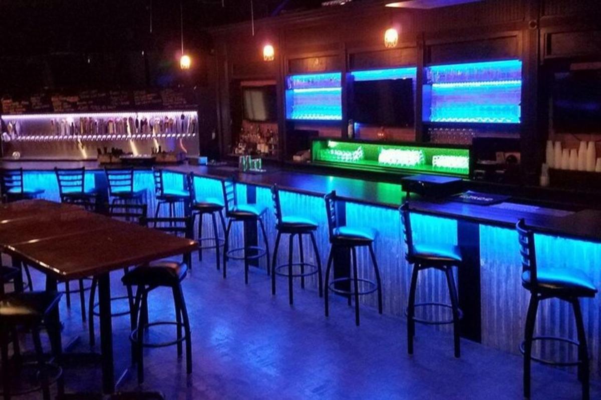 Bar með bláum ljósum í bar með barstólum