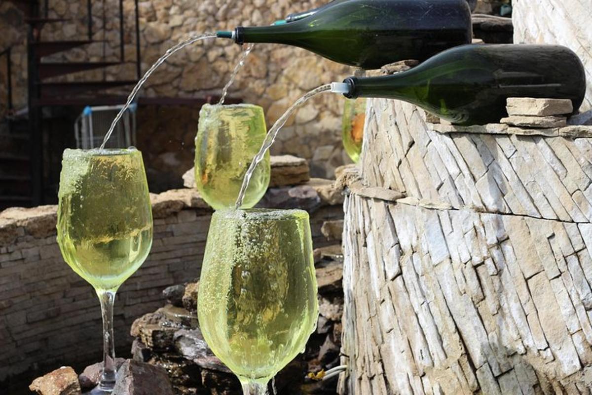 drei Gläser Wein stehen auf einigen Felsen
