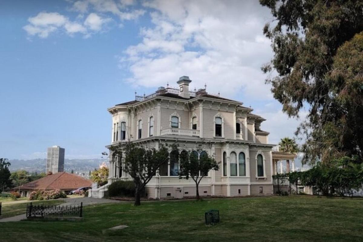 una grande casa bianca su un campo erboso