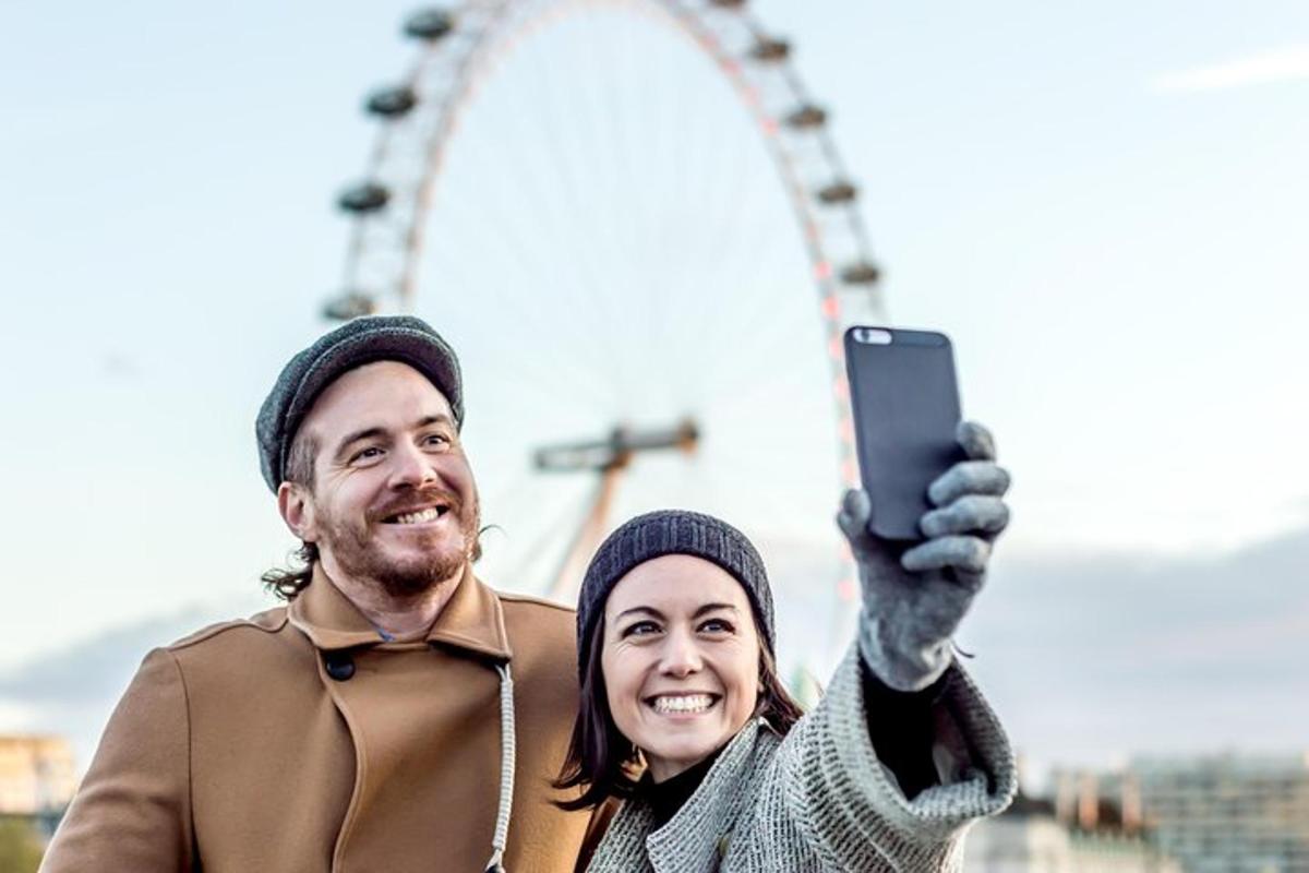 en mann og en kvinne som holder opp en mobiltelefon