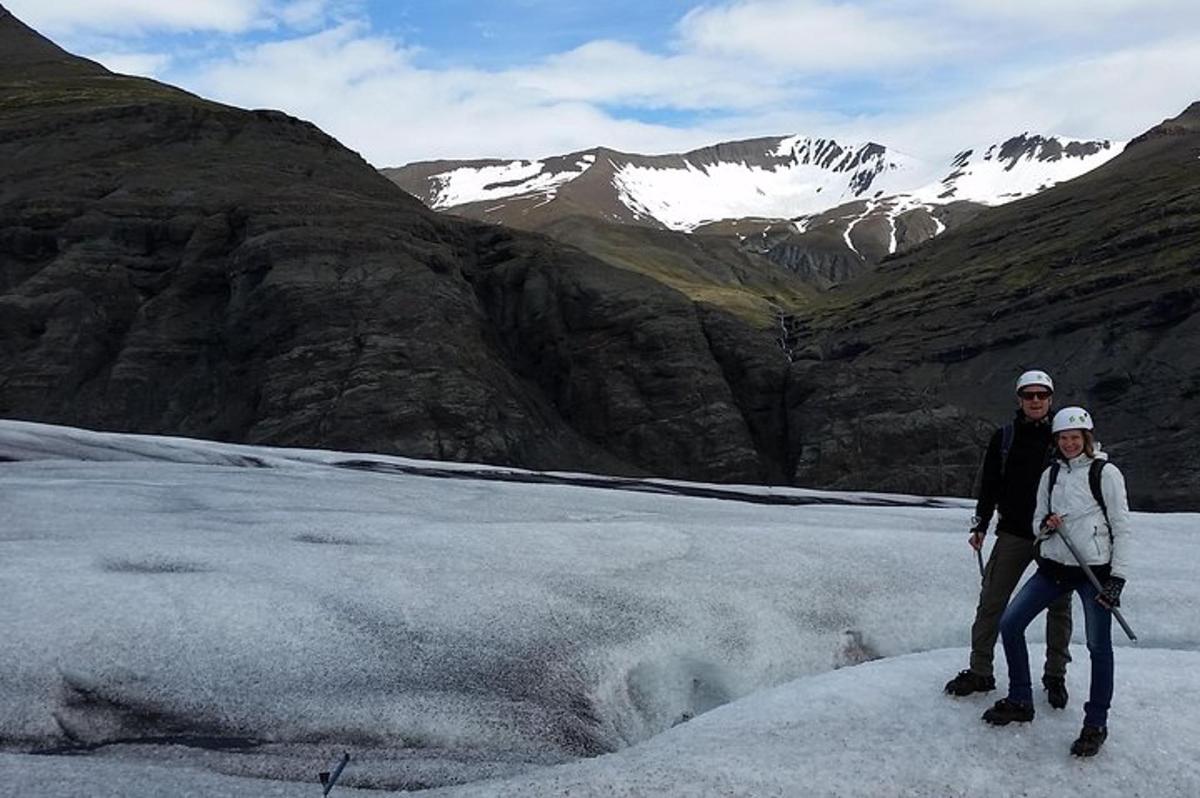 a man and a woman standing on top of a glacier