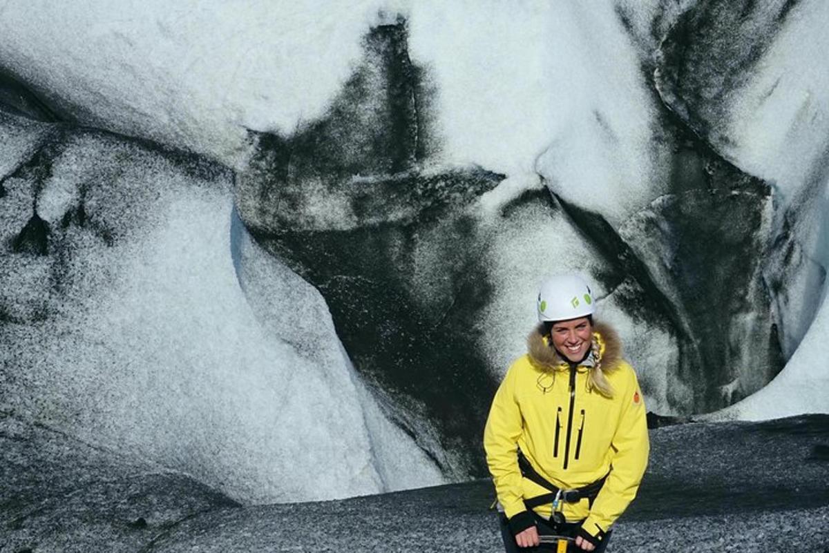 a person in a hardhat standing in front of a glacier