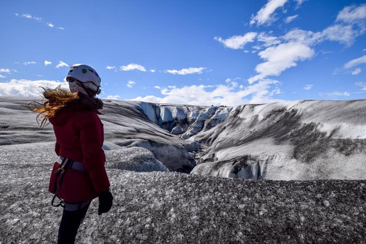 a woman standing on top of a mountain looking at a glacier