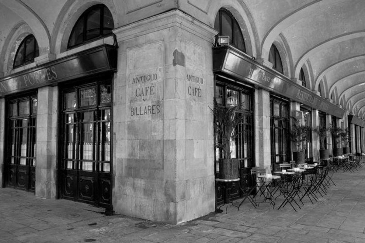 a black and white photo of a building with tables and chairs