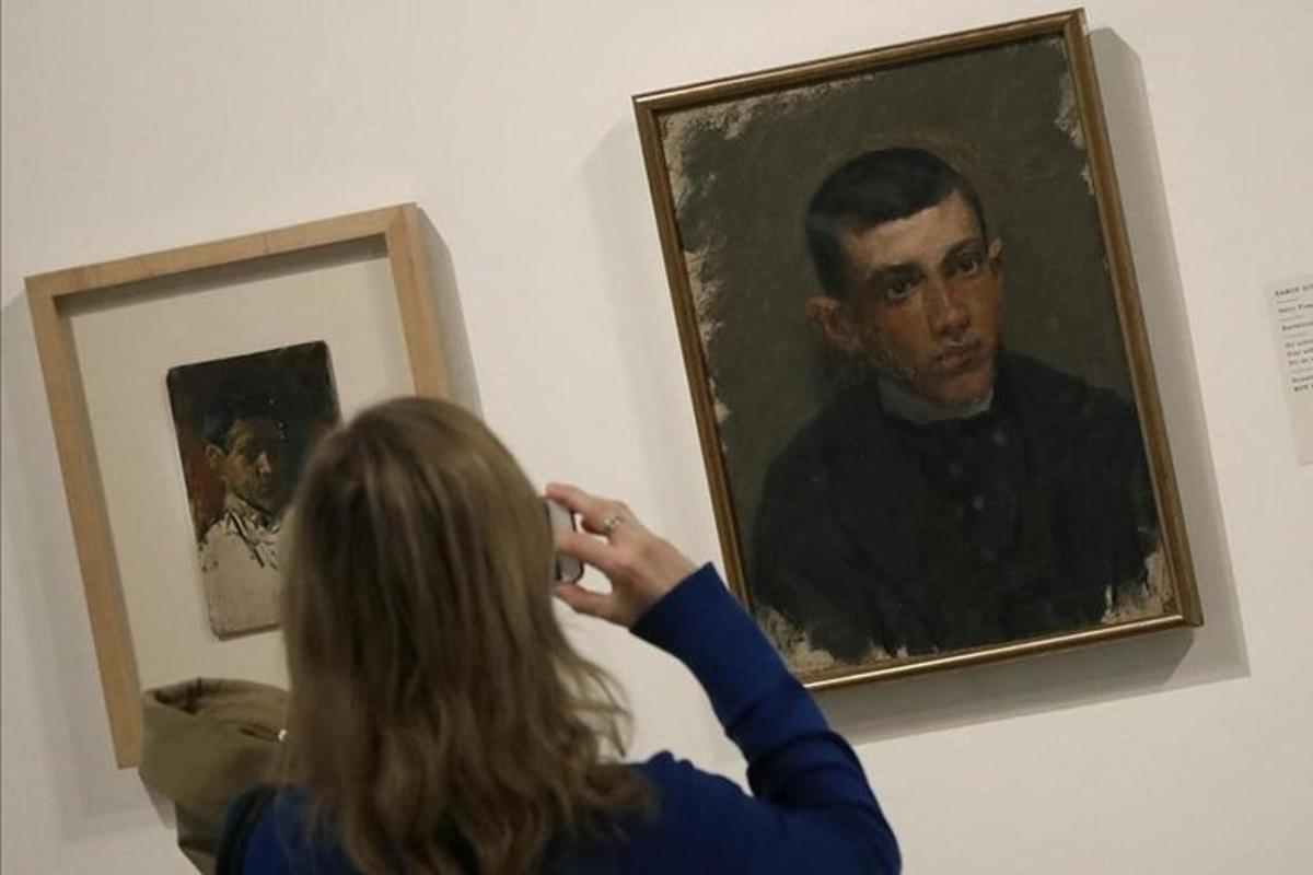 a woman taking a picture of a painting of a man