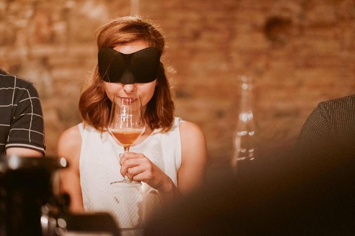 una donna con un visiera in testa che tiene in mano un bicchiere di vino