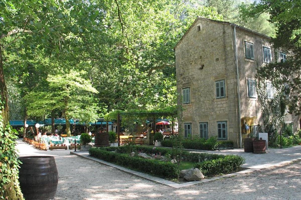 un antic edifici de pedra amb un jardí al davant
