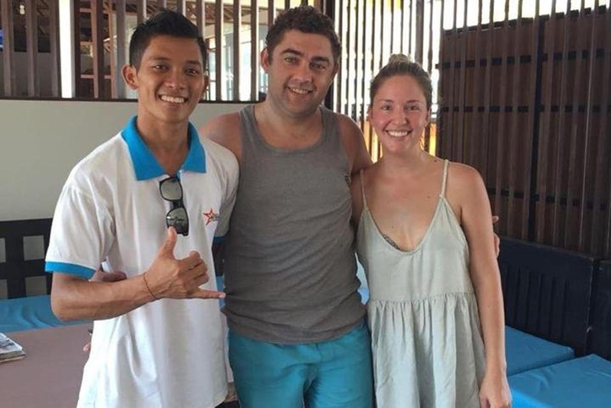 Dos hombres y una mujer posando para una fotografía