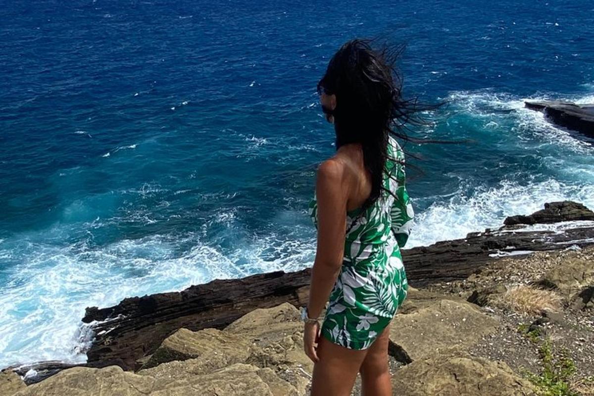 una donna in piedi sulle rocce vicino all'oceano