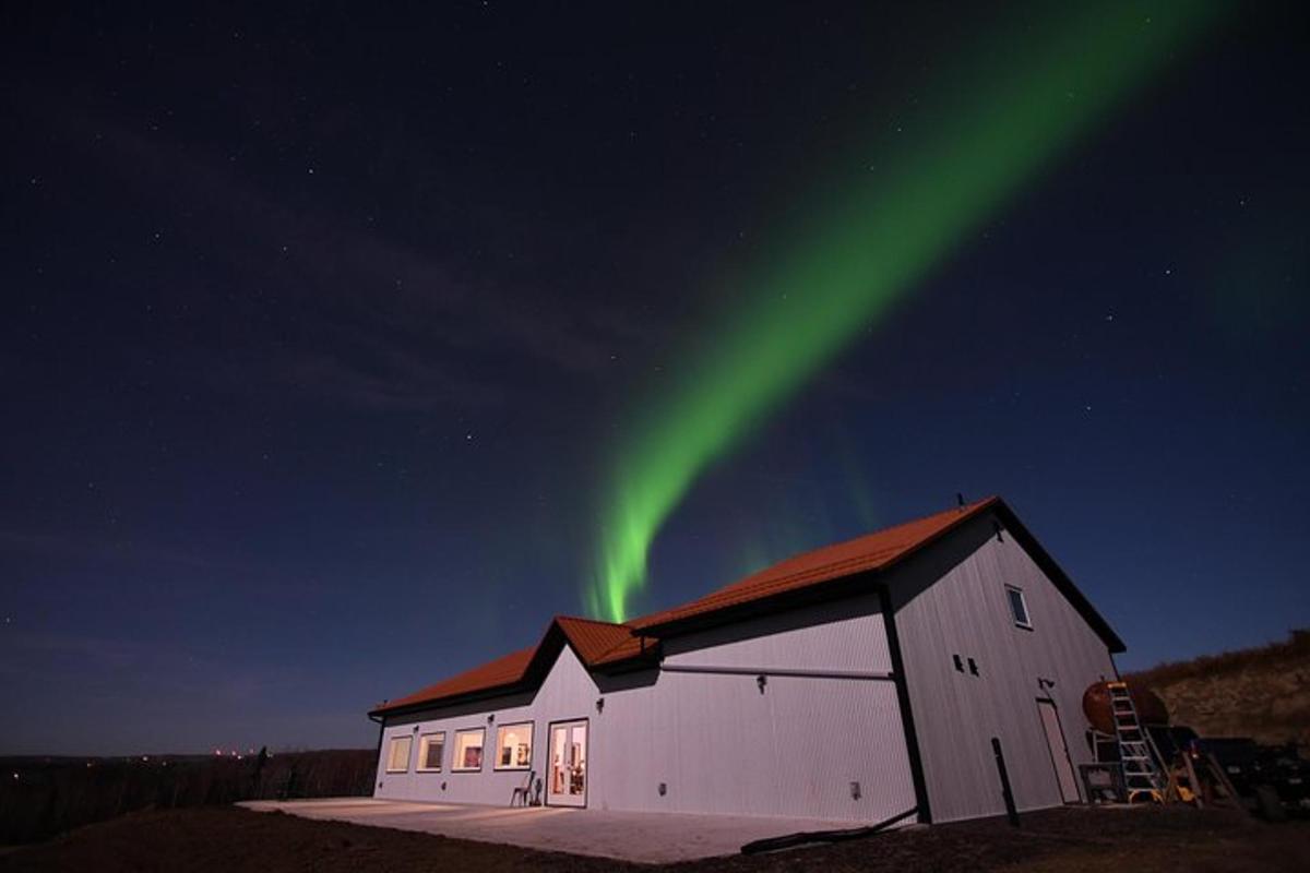 un fienile con una luce verde nel cielo