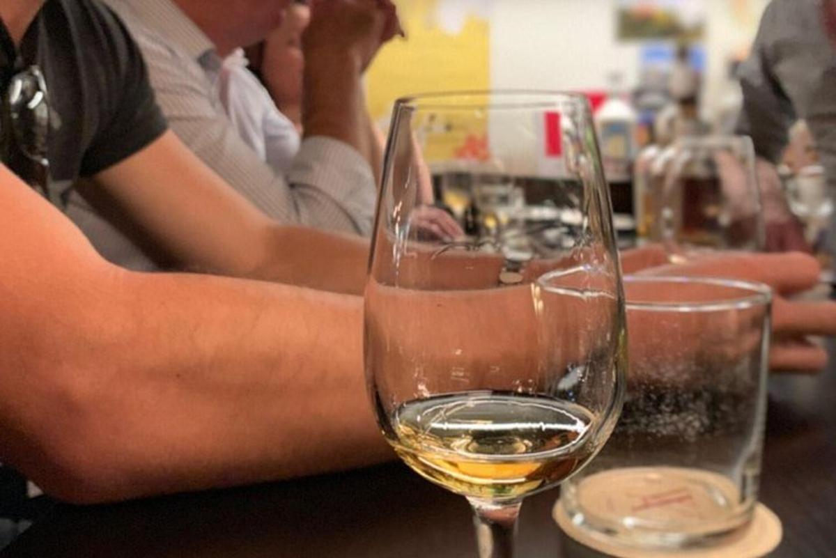 skupina lidí sedících u stolu s vinnými sklenicemi