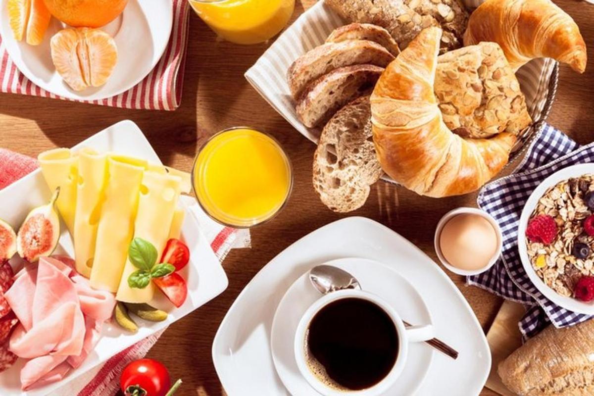 a table with breakfast foods and a cup of coffee