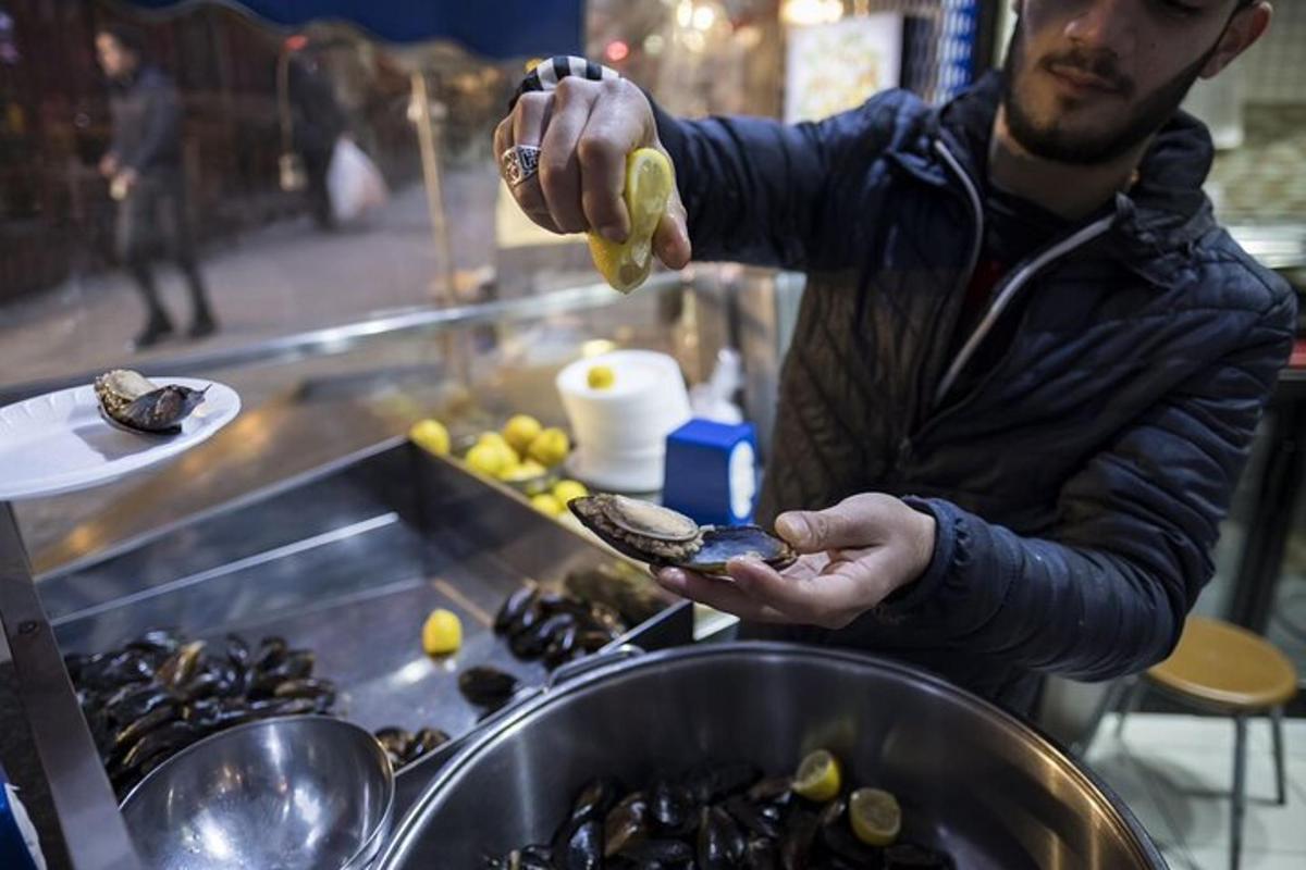 ένας άντρας κρατάει ένα μύδι στο χέρι του