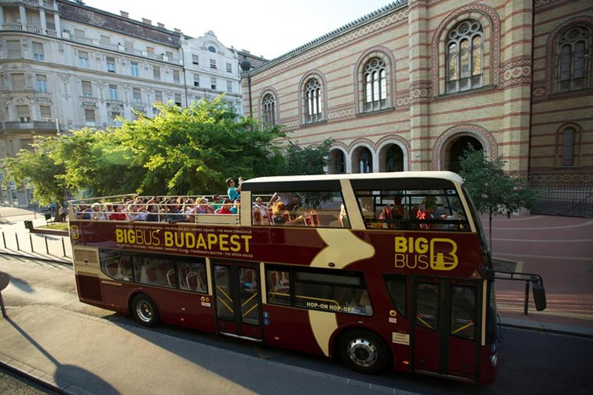 a red double decker bus driving down a street
