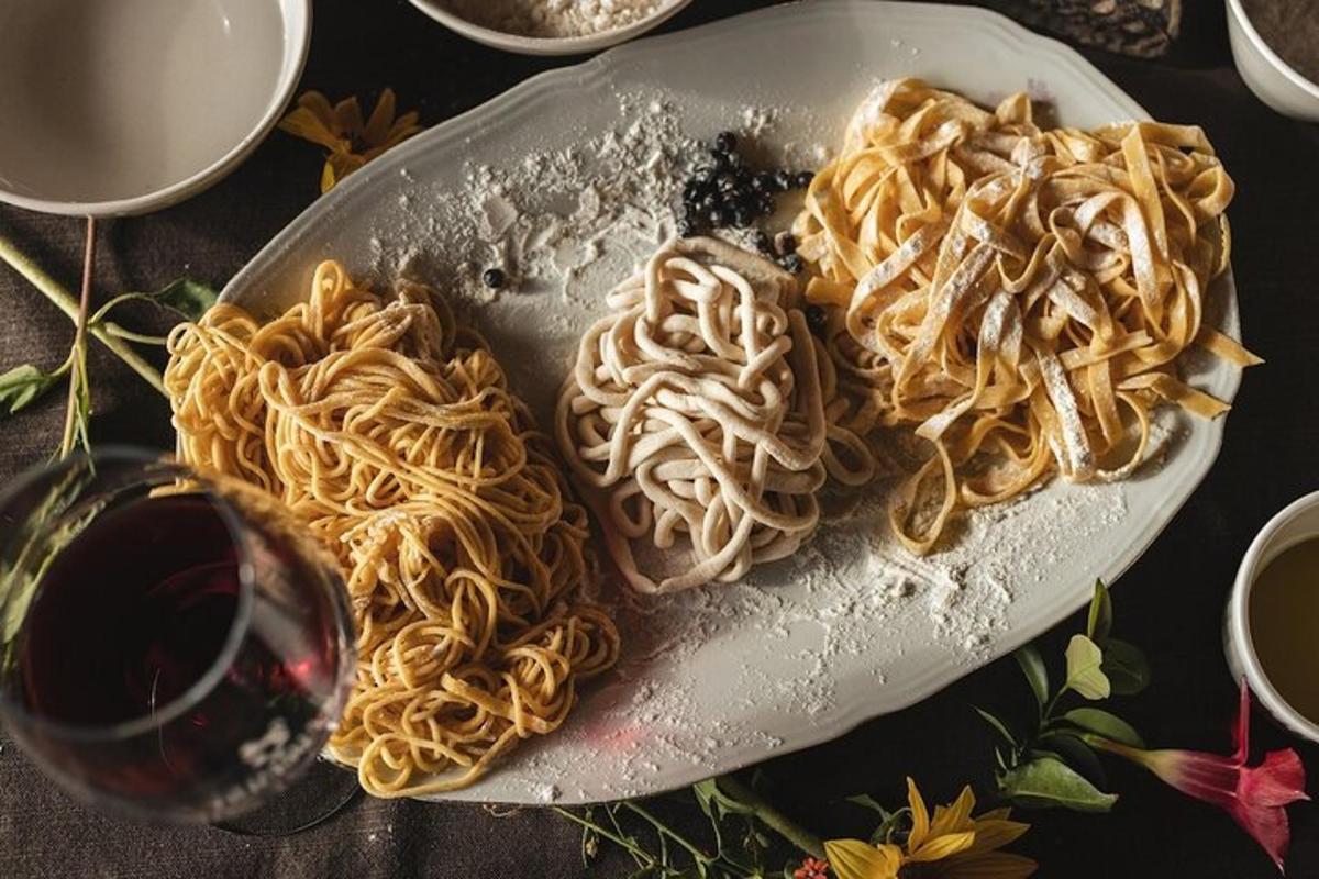 テーブルの上に置かれたパスタの皿とワインのグラス