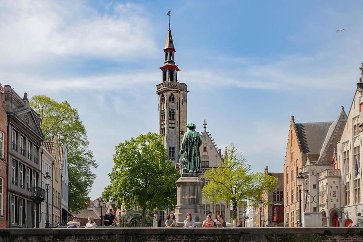 Una torre de reloj con una estatua en el centro de una ciudad.