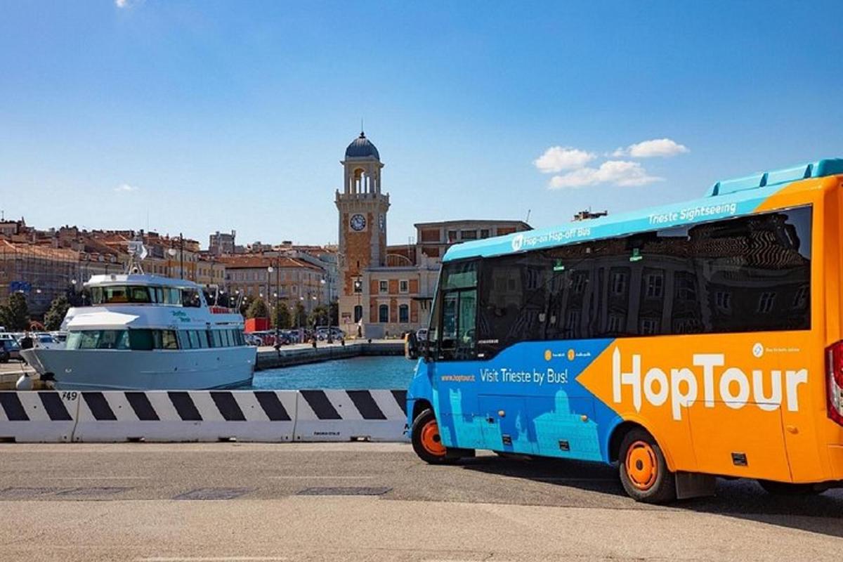 a bus is parked next to a harbor with a boat