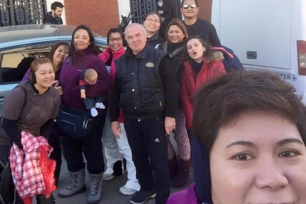 a group of people standing in front of a car