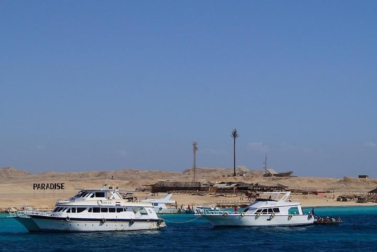 three boats sitting in the water near a beach