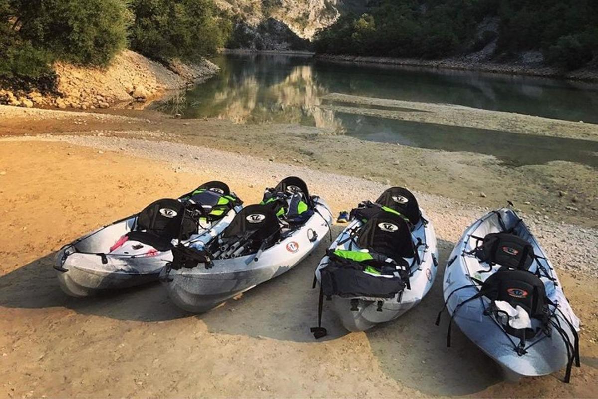three canoes sitting on the shore of a river