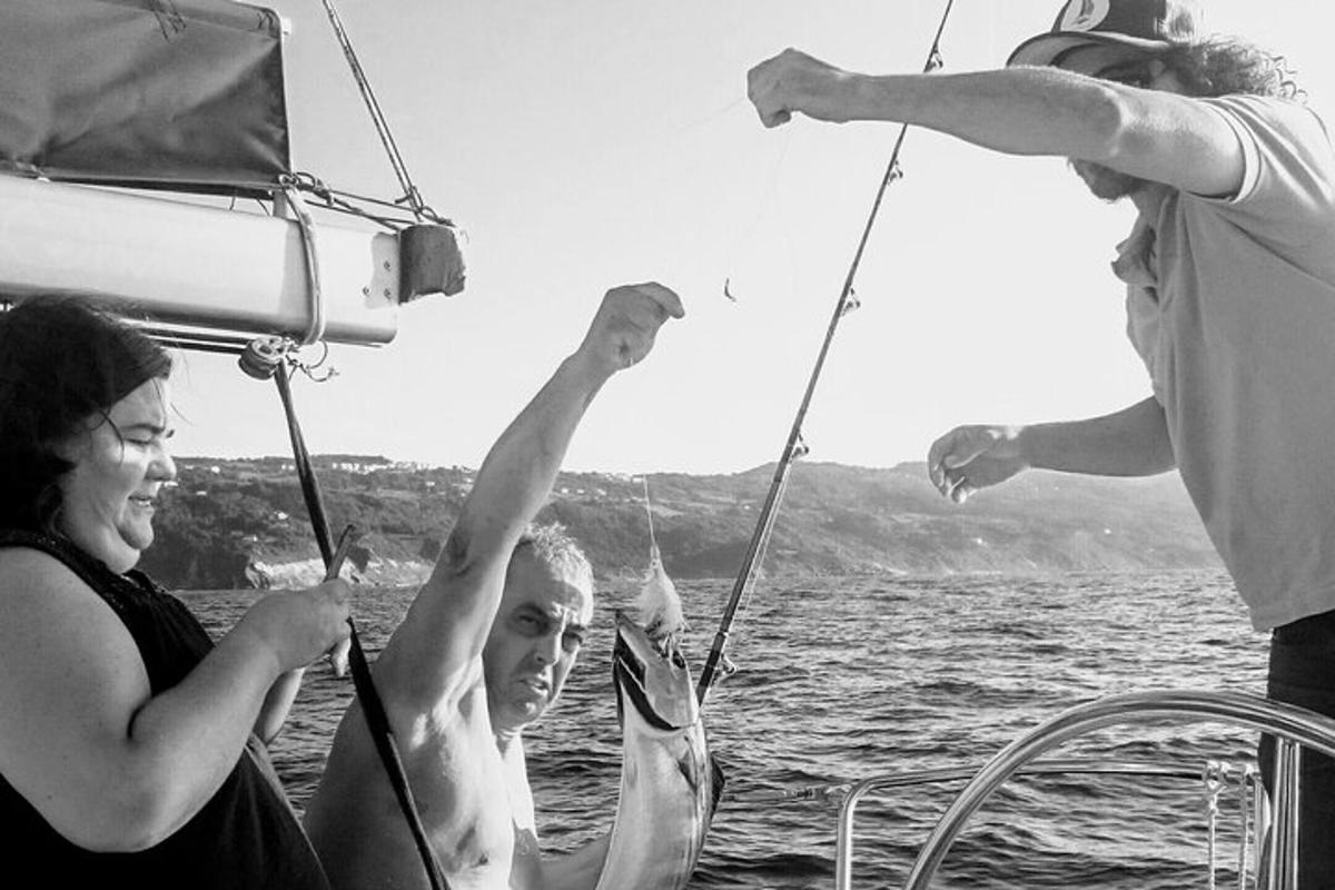 kolm inimest paadis käed õhus