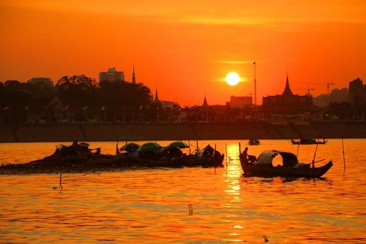 un gruppo di barche in acqua al tramonto