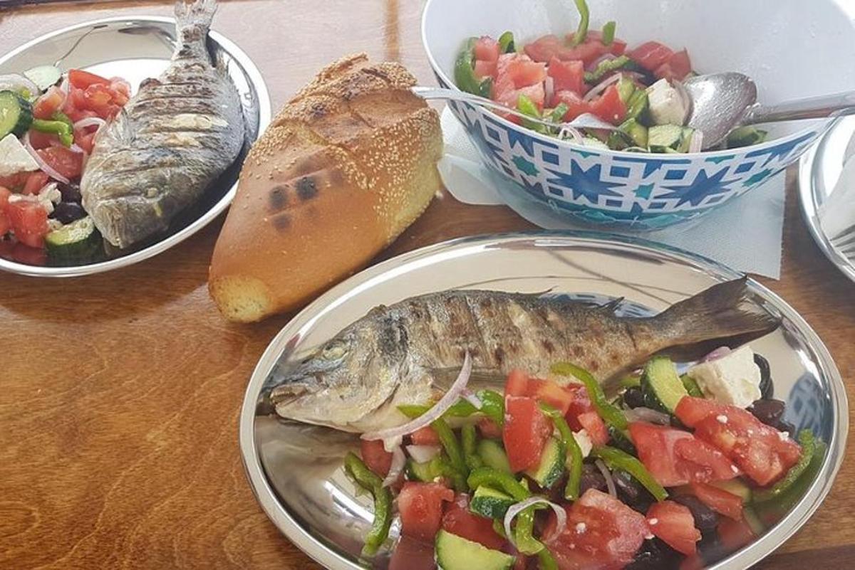 et bord med tre tallerkener med mat, fisk og salat