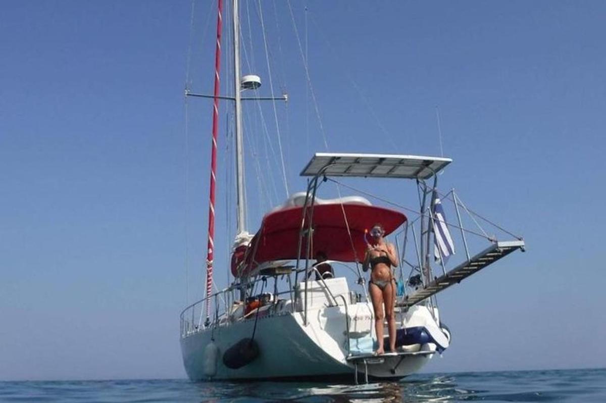 isang babaeng nakatayo sa isang layag na bangka sa tubig