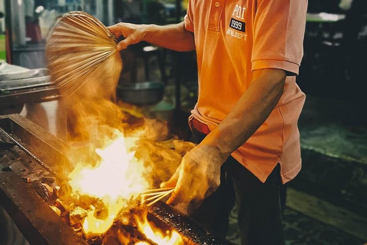 a man cooking food on a grill with flames