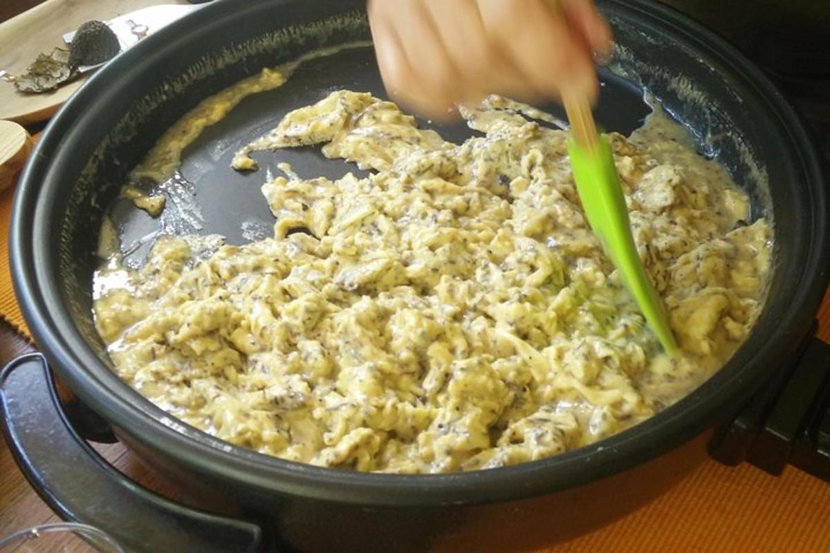людина, яка змішує їжу на сковороді зеленою ложкою