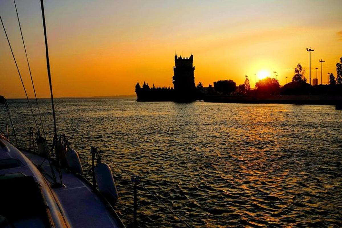 Una puesta de sol con una torre de reloj y un barco en el agua.