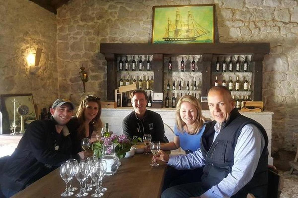 μια ομάδα ανθρώπων που κάθονται σε ένα μπαρ με ποτήρια κρασιού