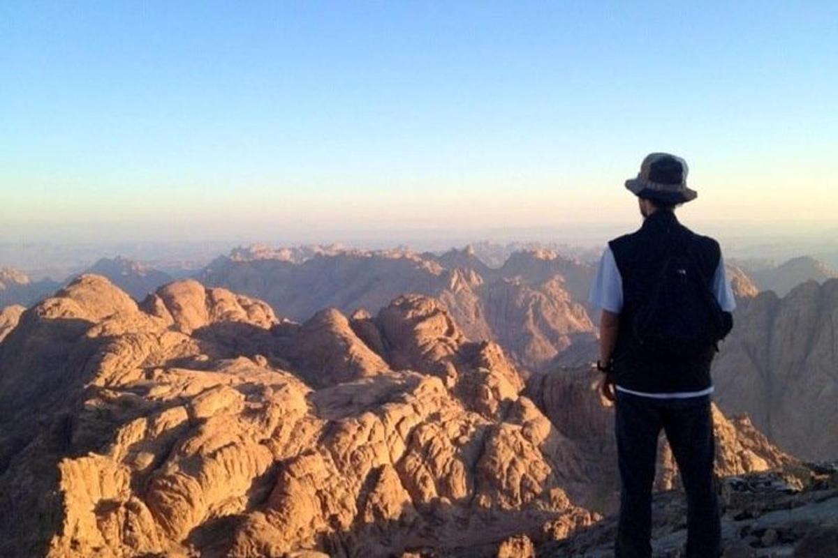 un hombre parado en la cima de una montaña