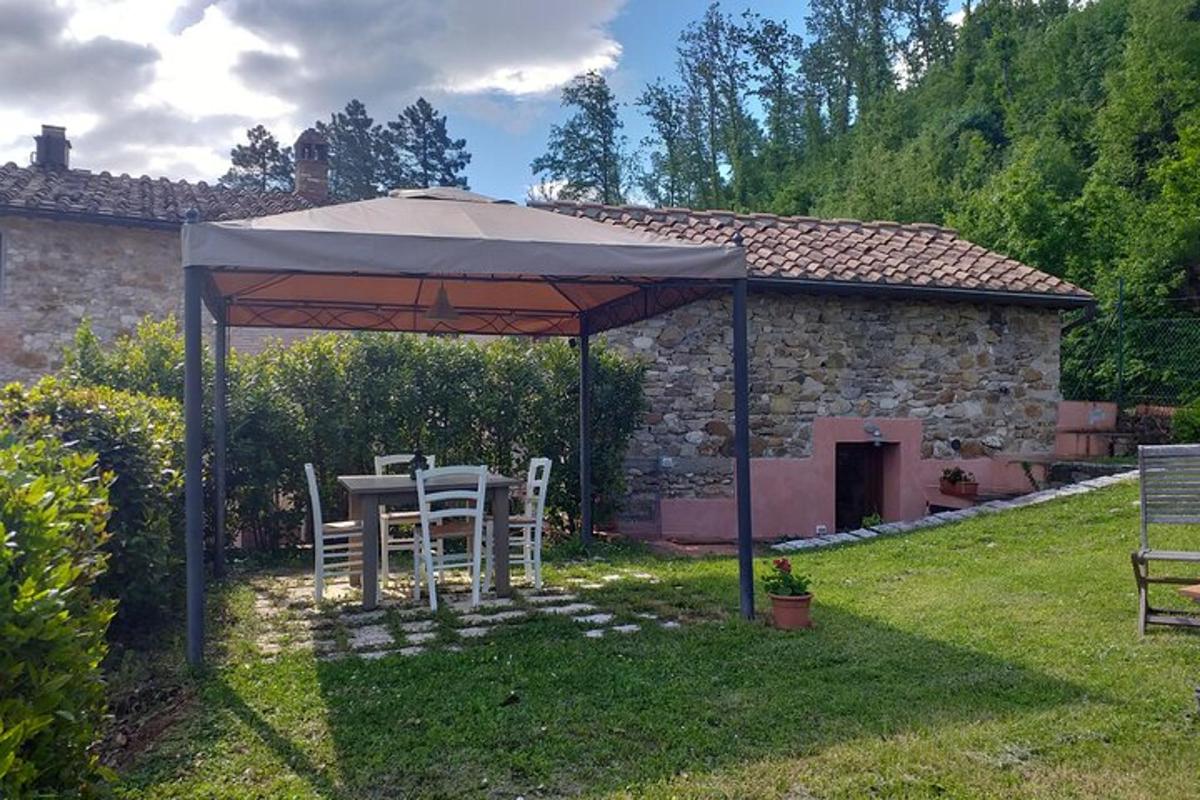 una taula i cadires sota un para-sol en un jardí