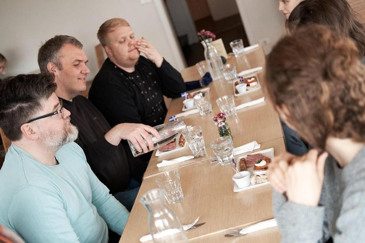 grupp inimesi, kes istuvad laua ümber ja söövad toitu
