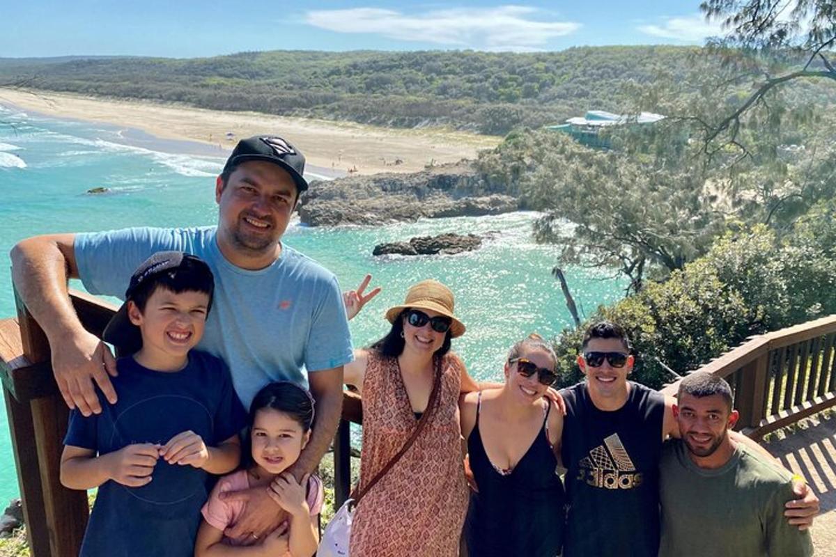 a group of people standing next to a beach