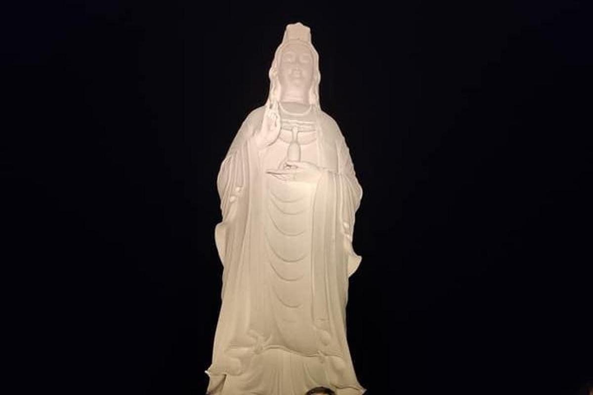 a white statue of a woman with a cross