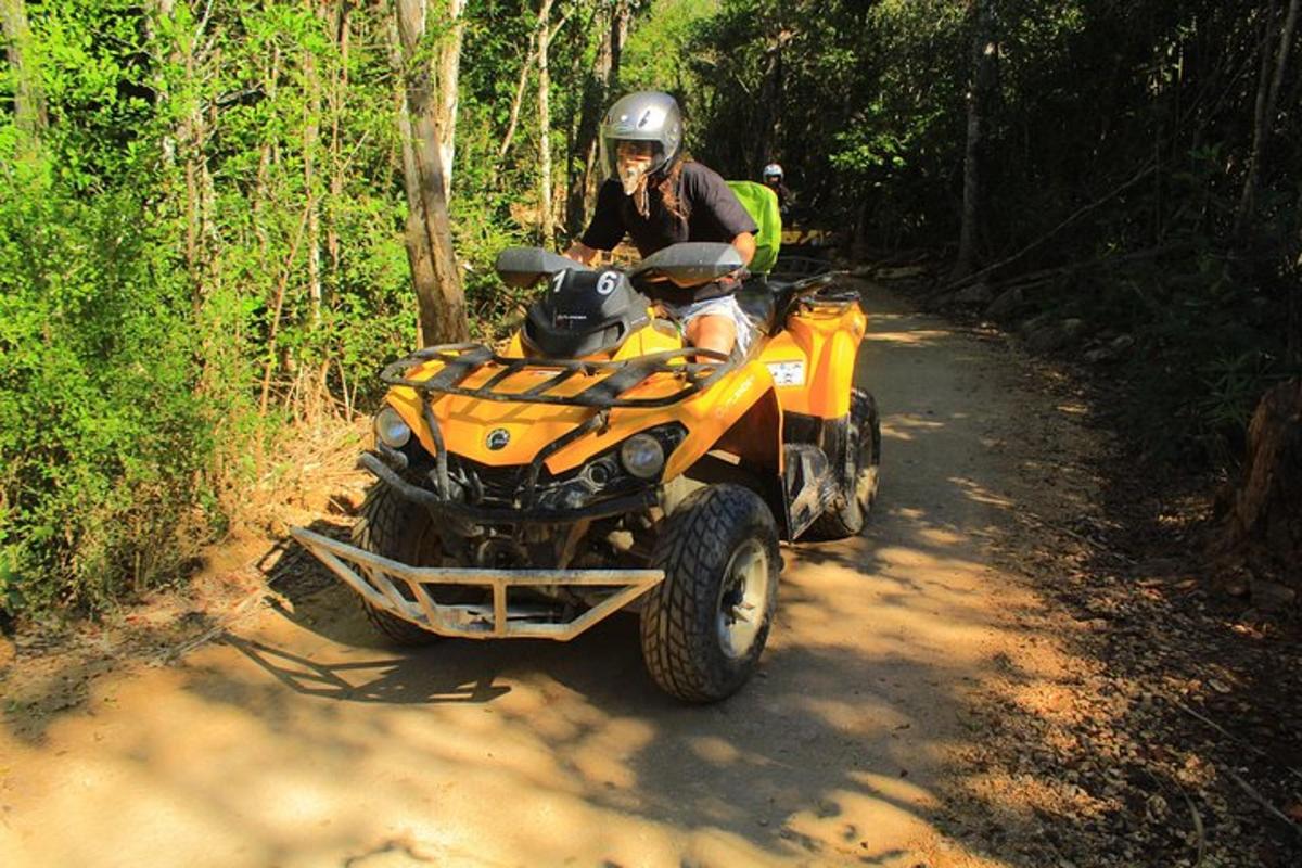 una persona che guida un quad su una strada sterrata