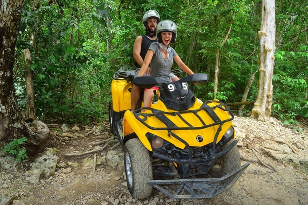 un uomo e una donna seduti su un quad su un sentiero