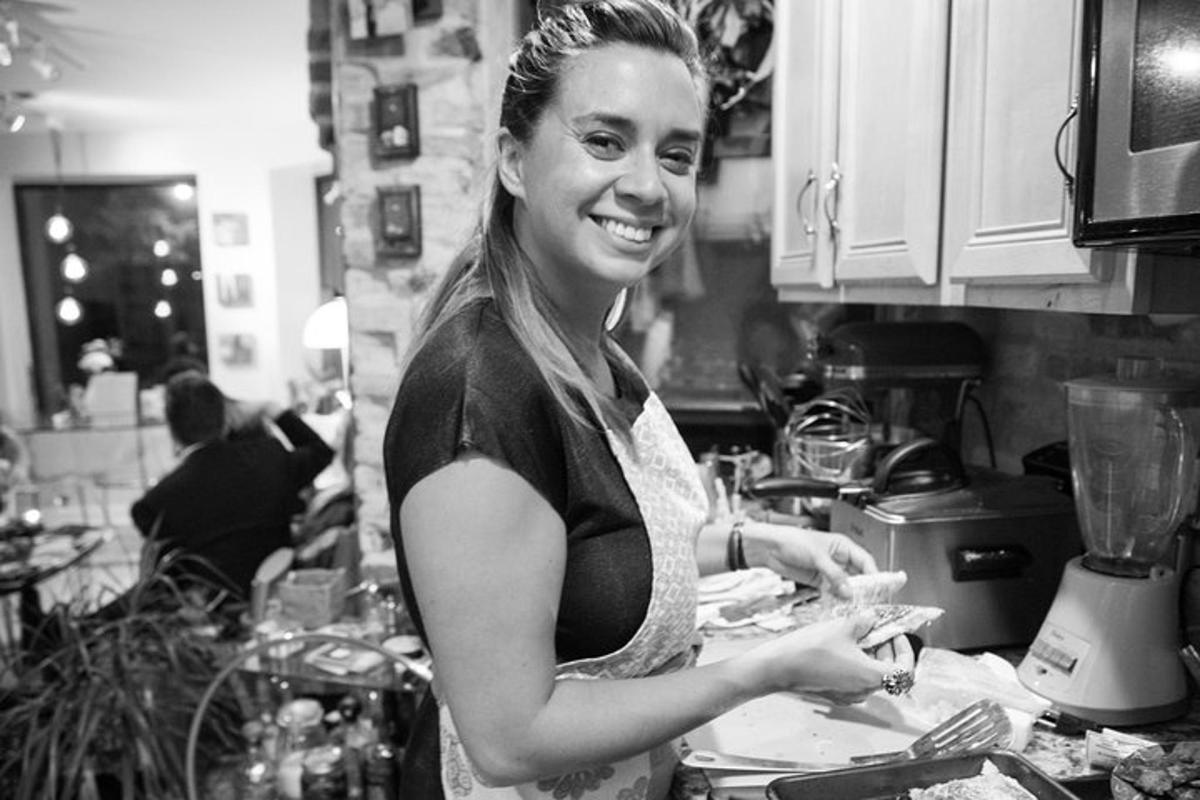 a woman standing in a kitchen preparing food