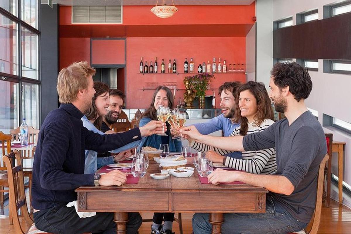 grupp inimesi istub laua ümber ja joob šampanjat