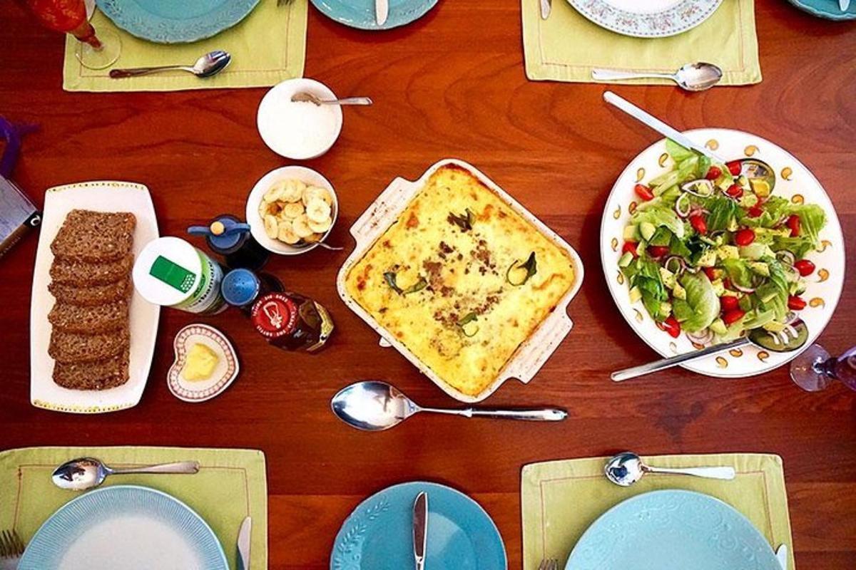 Una mesa de madera con platos de comida y una ensalada.