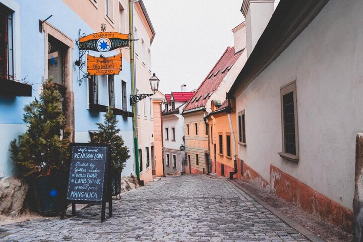 uma rua de paralelepípedos em uma cidade velha com uma placa