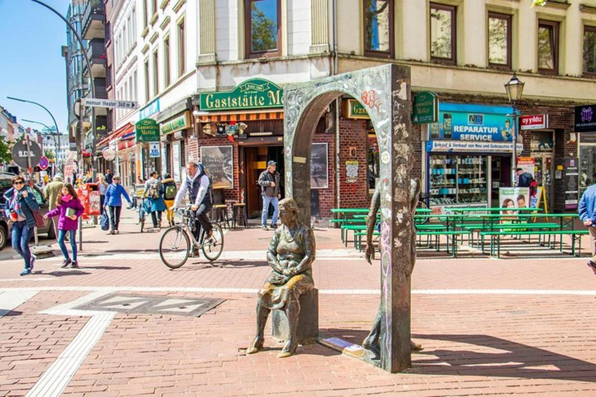 uma estátua de uma mulher sentada em um banco em uma rua da cidade