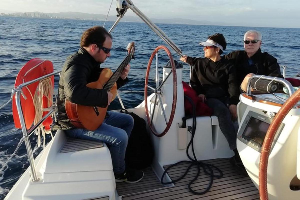 drie mannen zitten op een boot en spelen gitaar